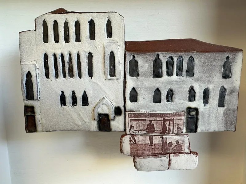 Cream and grey ceramic buildings with pointed windows and rust-coloured printed details